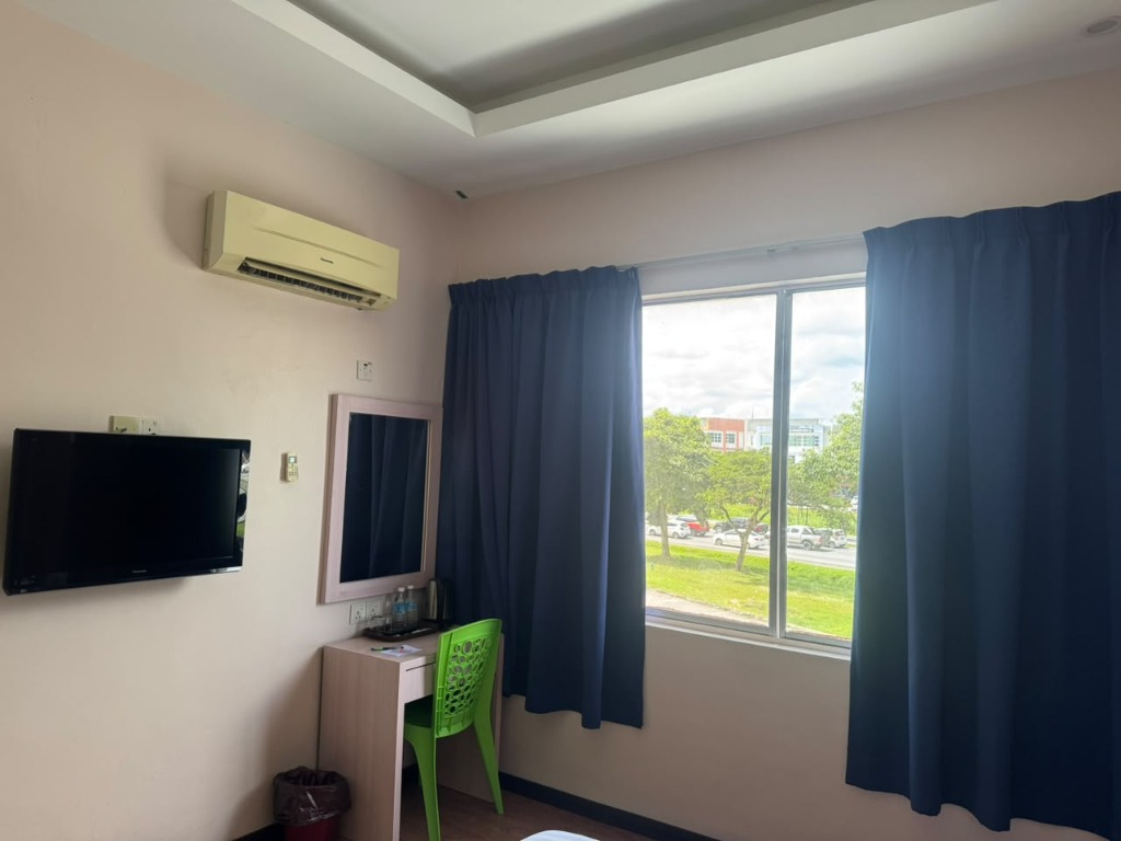 Salim Inn guest room with window, television, work desk and air-conditioning